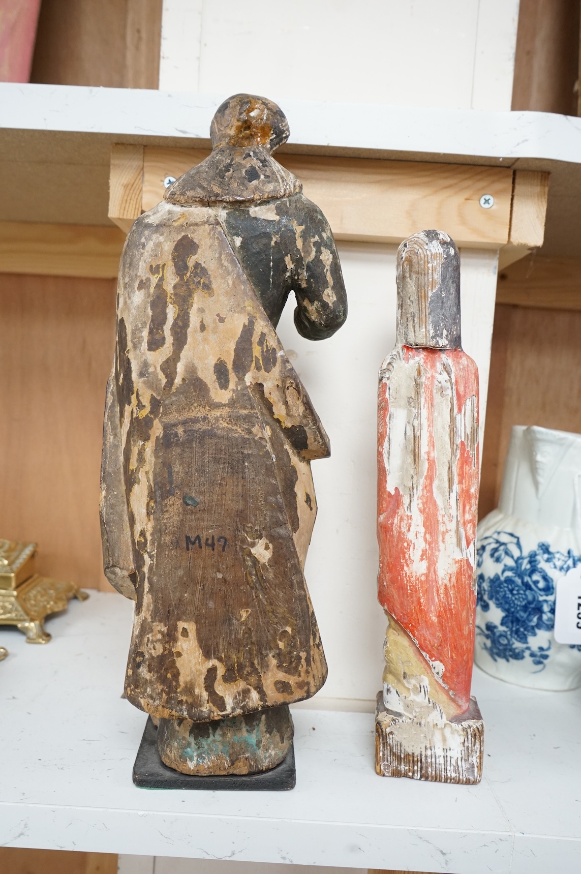 An antique carved wood figure of a Saint, traces of old paint and another figure, largest 36cm high (2)